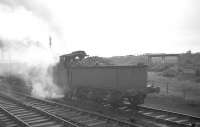 View south east in 1963, showing a Caley 0-6-0 with a train of gunpowder vans in the Ardeer ICI sidings by Stevenston No 1 signalbox. To the immediate right is the trackbed of the Misk branch which carried a workers passenger service to the single platform Ardeer station (served by both CR and G&SW). In particular this branch served the Nobel explosives works. On the horizon is the disused trackbed of the Lanarkshire and Ayrshire Railway. Today (2012) the ICI sidings seen here (which ran along the southern edge of the Ardrossan line) are lifted but the overgrown Misk branch remains in place. <br><br>[R Sillitto/A Renfrew Collection (Courtesy Bruce McCartney) 25/05/1963]