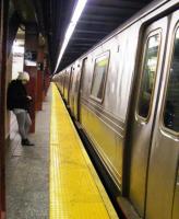 A lonely passenger waits at 34th Street Subway station, New York City, on 24 February 2012. Note the length of the platform and its occupying train<br><br>[Colin Harkins 24/02/2012]