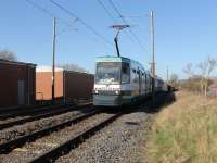 Metrolink No. 1023 leads a brace of trams at maximum speed (50mph) south from Bury towards Radcliffe on a Manchester Piccadilly service. They have just crossed the short viaduct over the River Irwell and are approaching the level crossing at Hagside. The signalling relay rooms can be seen alongside the northbound track. <br><br>[Mark Bartlett 26/03/2012]