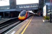 An up Pendolino passing Nuneaton platform 4 at about 100mph on 1 April 2012. Notice the cut-back end of platform 3 on the left - this was damaged by the sleeper derailment in 1975 and has never been restored. Notice also the contrast between the original cross-station footbridge and the extension spanning the recently built platforms 6 and 7 to the right.<br><br>[Ken Strachan 01/04/2012]