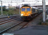 Sometimes the old techniques come in handy. Panned shot of Freightliner 66620 passing Nuneaton platform 5 with a train of fly ash on 1 April 2012. The train had come off the Leicester line; the parallel track on the left would offer an alternative connection, had it been commissioned - hence the rust.<br><br>[Ken Strachan 31/03/2012]
