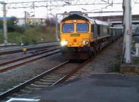 Sometimes the old techniques come in handy. Panned shot of Freightliner 66620 passing Nuneaton platform 5 with a train of fly ash on 1 April 2012. The train had come off the Leicester line; the parallel track on the left would offer an alternative connection, had it been commissioned - hence the rust.<br><br>[Ken Strachan 31/03/2012]