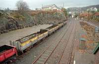 Your eyes do not deceive you. That is freight at Kyle of Lochalsh. Back in January of 1997 an experimental timber train was loaded at Kyle for Workington, the first freight in 15 years. That was followed in March by this train, carrying 250 tonnes of Caithness flagstone for the 'Kyle Prospect' development. The train had been loaded at Georgmas Junction, with feed destined for fish farms added at Inverness. The unloaded flagstones can be seen piled in the background. The same train was then loaded with further timber destined for Workington. [See image 36320]<br><br>[Ewan Crawford 21/03/1997]