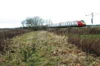 The Dolphinton Branch (opened 1867) met the mainline of Caledonian Railway at Dolphinton Junction, Carstairs. This junction was also (from 1872) the east junction of the Carstairs triangle and is today more appropriately called Carstairs East Junction. This 2004 view looks west from the former Dolphinton Branch trackbed (closed 1950) and shows a train taking the east to south curve. Dolphinton Junction was slightly further west than Carstairs East Junction as today's curve is an amalgam of the original curve and a later additional curve on an easier alignment - the curve incorporates the original hard curve away from the east end of the station and the later curve's further east junction.<br><br>[Ewan Crawford 22/12/2004]