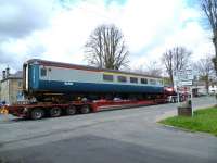 Quite a sight at Newcastleton on 16 April 2012. Mk 2 RFO no 1215 in InterCity blue and grey livery passes through on a low-loader heading for the Waverley Heritage Centre at Whitrope.<br><br>[Bruce McCartney 16/04/2012]