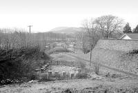 Scene in Peebles in 1975 looking south from the A702 Innerleithen Road along the former link line from Peebles NB (Peebles Junction) to an end on junction (Peebles CR and NBR Junction) at Caledonian station on the other side of the Tweed. The 3-bar fence in the centre stands on the north side of Walker's Haugh and, less than 20 yards beyond, is the western abutment of another bridge, since filled in [see image 29950], on Tweed Avenue. A triangular junction was once mooted for this particular location.<br><br>[Bill Roberton //1975]
