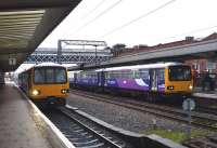 A wet evening at Wakefield Westgate on 18 April 2012, with trains for Huddersfield [left] and Leeds awaiting their departure times.<br><br>[John Steven 18/04/2012]