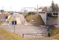 View east showing the recently commissioned north side car park at Uphall station on 17 April 2012, as a Glasgow bound service pulls away from the platform.<br><br>[John Furnevel 17/04/2012]