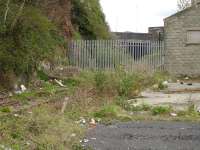 Track still in place near the roundabout at the entrance to Milford Haven station on the former line to Milford Haven dockside in April 2012. Victoria Road overbridge stands beyond the palisade fence. <br><br>[David Pesterfield 18/04/2012]