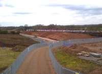 How long is that new embankment for the Nuneaton North Chord? Oh, about the same as a 9-coach Pendolino. Scene on 17 March 2012 with the ballast-filled soakaway on the left, and the wooden level posts on top, giving an impression of progress - just as well, as the entire project is due to be finished in July [see image 36137]. Note the sharp ramp up to the soon-to-be-demolished bridge over the WCML adjacent to the power car on the left.<br><br>[Ken Strachan 17/03/2012]