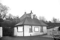 View from the car park at West Kilbride station in February 1963. The solitary vehicle visible in the car park is [thanks to Ken Strachan] a Humber <I>Super Snipe</I>, 'containing more steel in its front bumper alone than can be found in many of today's cars'. Additional period touches are provided by the car's spotlights, AA badge and wing mirrors. [Editors note: The building was demolished after the body of a murdered woman was found in it in 1995.] [With thanks to Colin Miller]<br><br>[R Sillitto/A Renfrew Collection (Courtesy Bruce McCartney) 25/02/1963]