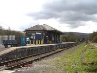 Pantyffynon station passenger side from the adjacent level crossing looking south to Pantyffynon Junction signal box in April 2012. The Gwaun cae Gurwen freight line runs past the far side of the station beyond the lifted former valley platform line. <br><br>[David Pesterfield 12/04/2012]