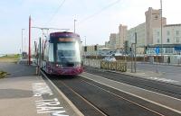 Tram 008, heading for Fleetwood Ferry, slows across the level crossing to call at Norbreck on 6 May 2012.  To the right of the tram is the Norbreck Castle hotel, a local landmark overlooking the cliffs.<br><br>[Mark Bartlett 06/05/2012]