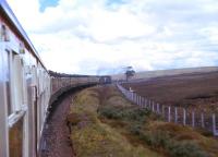 The special train run to commemorate the centenary of the 28th July 1874 opening of the final phase of the Far North Line powers up the gradient from Forsinard to the County March Summit, headed by two Inverness Class 26s. At that time there were no Sunday trains north of Lairg, although a through train of newspaper vans from Manchester Victoria ran to Lairg on Sunday mornings, returning to Inverness as a passenger service.<br><br>[David Spaven 28/07/1974]