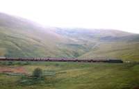 With Arnton Fell as a backdrop, a 'Peak' at the head of <I>The Waverley</I> battles north up the 1 in 75 towards Riccarton Junction in the summer of 1963. The following year this ceased to be a complete through train, with just two coaches from St Pancras to Edinburgh (running as part of The Thames-Clyde Express as far as Carlisle).<br><br>[Frank Spaven Collection (Courtesy David Spaven) //1963]