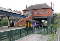 Passing under the street level L&YR booking office to run non-stop through Poulton-le-Fylde station is a Blackpool North to Liverpool service, formed by 156489. In the foreground the old through line trackbed can be seen, now used for car parking. <br><br>[Mark Bartlett 17/05/2012]