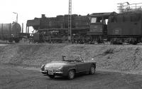 The photographer's conveyance of the time provides some additional interest to this shot of class 50 2-10-0 No. 050 253, seemingly put out to grass at Schwandorf MPD in late summer 1974.<br><br>[Bill Jamieson 25/08/1974]