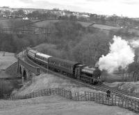 KWVR 0-6-0ST <I>Fred</I>, built as RSH 7289/1945 and employed prior to preservation by the NCB at Walkden and Leigh collieries. The loco, which had been modified with a gas producer combustion system (including a very distinctive chimney) in 1963, was initially preserved on the KWVR where it is seen working uphill between Mytholmes Viaduct and Tunnel with a motley collection of coaches in March 1976. It has since migrated south and is currently based at Tyseley.<br><br>[Bill Jamieson 28/03/1976]