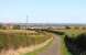 View east at Low Moor Crossing, Fenham le Moor, Northumberland on 5th April 2012. An up CrossCountry service runs through the crossing, with the holy island of Lindisfarne in the background. <br><br>[Brian Taylor 05/04/2012]