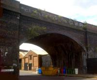 Conventional wisdom tells you that Birmingham's Duddeston viaduct was built as a ploy to further the GWR's interests, and was neither completed, nor used. However, this painted message ('Bordesley cattle station GWR') tells you the truth; that sidings were laid from Bordesley station along part of the deck to accommodate cattle traffic. Part of Bordesley viaduct, which is still in use, can just be seen above the factory rooftops through the arch; while the wide variety of waste containers under the bridge demonstrates that some form of industry survives in these parts.<br><br>[Ken Strachan 10/06/2012]