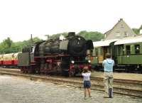 Making too much noise for one young onlooker, DB 44 004 2-10-0 runs round its train at Bad Laer in July 1990. A fine collection of 4 wheel coaches waits to carry the passengers on the Teutoburger Wald Eisenbahn back to Lengerich.<br><br>[John McIntyre /07/1990]