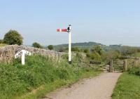 When the gradient post reads <I>1 in 1056:1 in 8 (and a quarter!)</I> you know this is a railway location with a difference. This is the summit of the Middleton incline, the upper of the two rope worked inclines on the Cromford and High Peak. The gate is a later addition, to slow down the cyclists, and I presume the semaphore has been brought here from elsewhere too. From the foot of Middleton was a one mile level section at Sheep Pasture worked by an isolated locomotive and then a further rope worked incline down to Cromford. <br><br>[Mark Bartlett 24/05/2012]