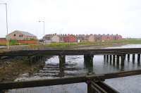 A dreich June day in 2012, looking across the cut - down remains of North Blyth staithes to the former railway settlement of that name. The building on the left is North Blyth WMC, once the BR Staff Assoc Club. The nearest street is named Worsdell Terrace (of J27 fame). The former steam shed was located to the left of the Club. It's diesel depot replacement was located at Cambois, a further mile to the left. The pedestrian ferry that ran from this point across the river to the town of Blyth was withdrawn in the 1980's - it is now many miles by road between the two settlements. <br><br>[Brian Taylor 15/06/2012]