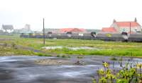 A Freightliner coal working, having departed from North Blyth terminal on 15 June 2012, creeps past the cleared site of Cambois Diesel Depot, with rain and North Sea haar making for awful photographic conditions. The building just visible above the locomotive is the listed former pit head baths of Cambois Colliery. The rest of the colliery site has been cleared. <br><br>[Brian Taylor 15/06/2012]