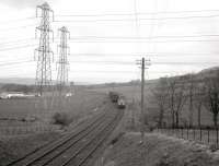 A Largs bound DMU working wrong-line passing a PW train on the morning of Easter Sunday 1963, during reballasting work at Kilruskin cutting, near West Kilbride. [See image 36606]<br><br>[R Sillitto/A Renfrew Collection (Courtesy Bruce McCartney) 14/04/1963]