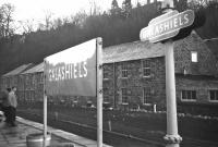 <h4><a href='/locations/G/Galashiels_1st'>Galashiels [1st]</a></h4><p><small><a href='/companies/E/Edinburgh_and_Hawick_Railway_North_British_Railway'>Edinburgh and Hawick Railway (North British Railway)</a></small></p><p>Seen from a carriage window of the 'Scottish Grand Tour No.6' railtour on 4 January 1969, the Edinburgh end running-in board at Galashiels station and a totem which hopefully now graces someone's study wall. The recently demolished (2012) Beechbank Mill, latterly converted to flats see image <a href='/img/39/258/index.html'>39258</a> forms a backdrop.</p><p>04/01/1969<br><small><a href='/contributors/Bill_Jamieson'>Bill Jamieson</a></small></p>