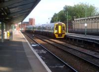 The 18.24 to Holyhead snakes across from a through line to platform 3 at Shrewsbury while crossing the River Severn in June 2012. The Abbey, having seen the Shropshire and Montgomeryshire Railway come and go, stands aloof in the distance.<br><br>[Ken Strachan 20/06/2012]