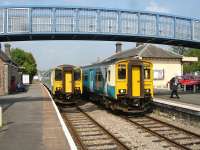 Crew change at Llandrindod Wells Station on 24 May 2012, with 150231 forming the 13.14 Swansea - Shrewsbury and 150256 the 14.04 reverse working. The driver of the latter is just setting off to walk towards the south end of the platform, to beyond the old signal box [see image 15415], in order to give up his token before he can cross over to take forward the Shrewsbury bound service.<br><br>[David Pesterfield 24/05/2012]