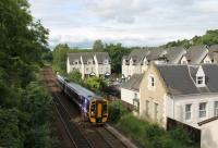 158735 slows to call at Bridge of Allan with a Sunday evening service for Edinburgh. The train is just passing the original station house. Bridge of Allan closed in 1965 but re-opened twenty years later on the opposite side of the road bridge. The modern houses behind were built in the old station yard.<br><br>[Mark Bartlett 01/07/2012]