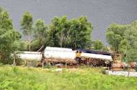 GBRf 66734 <I>'The Eco Express'</I> lying alongside Loch Trieg on 4 July 2012 following derailment in the aftermath of a landslip on 28 June. The locomotive will be particularly difficult to recover from this inaccessible spot, although the tank wagons are due to be lifted clear fairly soon. [See image 44705]<br><br>[John Gray 04/07/2012]