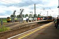 A Freightliner Class 66 waits with a container train at the north end of Ely station on 4 July 2012 for the road west towards Peterborough as a Class 365 at Platform 1 is about to depart for Kings Lynn.<br><br>[John McIntyre 04/07/2012]