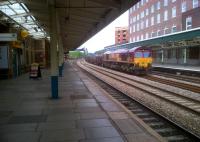 Somebody told me there wasn't much freight in South Wales any more. They were wrong. 66090 hauls empty steel coil wagons off the River Usk bridge and through Newport station on 20th June. The new brickwork on the right is part of the conversion of the old station booking hall into a council information centre. The Upper Crust cafe on the left survives, somewhat improbably, adjacent to the walled-up steps to the old footbridge, at the opposite end of the station to all of the other passenger facilities.<br><br>[Ken Strachan 20/06/2012]