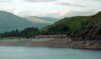 A 37 hauled southbound sleeper approaches the Loch Treig Tunnel on the deviation in 1995. At a lower level the original course of the line can be seen - the earlier route did not have a tunnel. The level of the Loch, used as a reservoir for the Lochaber Smelter, was unusually low at the time of the photograph revealing the old trackbed which is normally under water.<br><br>[Ewan Crawford //1995]