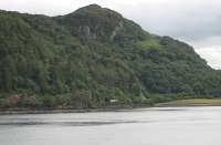 The 1715 from Kyle to Inverness approaches Stromeferry negotiating the sharp curves along the shore of Loch Carron. 158705 was photographed from the ruined Strome Castle on the opposite bank, near where the car ferry crossed the loch narrows until the new A road was built alongside the southern shore in the late 1960s.<br><br>[Mark Bartlett 10/07/2012]