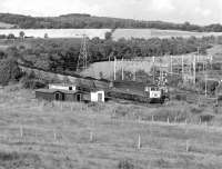 56082 eases a train of loaded HAA coal hoppers off the branch from Barrow Colliery at Wombwell Main Junction in the summer of 1981. From here the train will take the electrified (but not for much longer) line to Wath Yard.<br>
<br><br>[Bill Jamieson 17/07/1981]