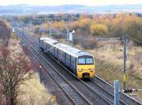 322484 approaching the 1988 Musselburgh station with a North Berwick - Edinburgh Waverley service on a slightly frosty November morning in 2002. In the background the line from Monktonhall Junction to the south end of Millerhill Yard runs off to the west, while on the right is the overgrown embankment via which the direct freight lines once climbed to Wanton Walls and Niddrie West Junctions [see image 29308]. <br><br>[John Furnevel 12/11/2002]