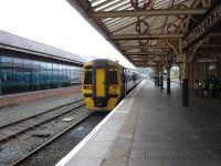 158823, seen reflected in the glazing of the store located on and behind the former platform 3, prepares to depart from what is now platform 1 at Aberystwyth with the 11.30 service to Birmingham International. Note the old steam shed standing beyond the platform end.<br><br>[David Pesterfield 10/05/2012]