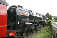 Preserved BR Standard class 9F 2-10-0 no 92214, now sporting the name <I>'Cock o' the North'</I> about to take a down NYMR train tender first over New Bridge level crossing shortly after leaving Pickering on 11 July 2012.<br><br>[John Furnevel /07/2012]