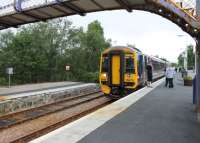 A guard's announcement that the train would be a few minutes in Lairg awaiting departure time led to a rush for the doors. I grabbed my camera but all the other <I>escapees</I> wanted a smoke break. 158711, seen here in the relocated southbound platform at Lairg, is on the 0812hrs second train of the day from Wick and Thurso to Inverness. The original station building is behind the camera. [See image 20565]<br><br>[Mark Bartlett 07/07/2012]