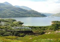 Beyond Fort William, the Mallaig Extension Railway is known for its steep gradients and tight curvature as well as impressive scenery. All three are illustrated in this photograph taken on 11 July 2012, which shows Black 5 No 45407 climbing the tightly curved 1 in 50 gradient out of Lochailort with <i>'The Jacobite'</i> steam service to Mallaig. Loch Ailort dominates the background.<br><br>[John Gray 11/07/2012]