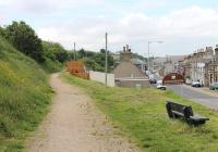 At the east end of Portgordon the Moray Coast railway and the road came together. This view looks west towards the village in July 2012 along the footpath and cycleway that uses the trackbed. For the view to the east from the same location [See image 30413].<br><br>[Mark Bartlett 03/07/2012]