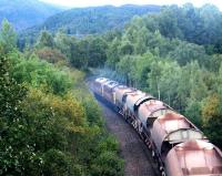 A ballast train returning south picks up speed shortly after passing through Aviemore in September 2004 behind a pair of EWS class 37 locomotives.<br><br>[John Furnevel 14/09/2004]