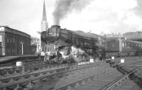 An interesting view of the west end of Newcastle Central, probably taken in the early 1960s, showing St Mary's Cathedral on Clayton Street in the background. The 1844 structure pre-dates Central station by 6 years. Meantime, the locomotive about to take out a train for the south is York shed's A1 Pacific no 60121 <I>'Silurian'</I>. <br><br>[K A Gray //]