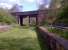 Several stations on the former 'back road' from Macclesfield [see image 39173] to Marple via Bollington are now informal picnic areas. This view looks North-West through one of the many bridges which had to be strengthened with an additional central support. The bushes on the left are close to the divergence of a former colliery tramroad.<br><br>[Ken Strachan 12/05/2012]