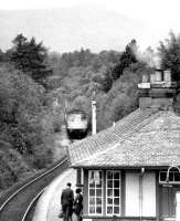 A Fort William - Glasgow Queen Street train approaching Helensburgh Upper station in June 1971. Note the smoke from the coal fire in the waiting room.<br><br>[John Furnevel 26/06/1971]