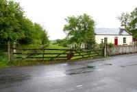 Looking south over Heriot level crossing and the surviving platform towards Galashiels on a wet morning in May 2004, with the old gates currently on the verge of collapse. [See image 3647]<br><br>[John Furnevel 05/05/2004]